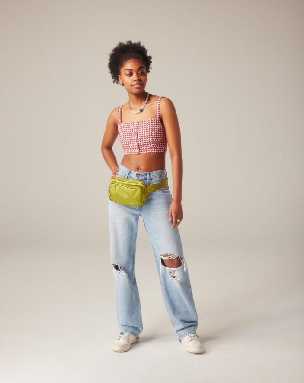 Eine Person in weiter Baggy Jeans und Sneakern, die einen lässigen Street-Style-Look verkörpert.