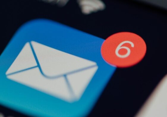 Nahaufnahme eines Smartphones mit E-Mail-Symbol und sechs neuen Nachrichten